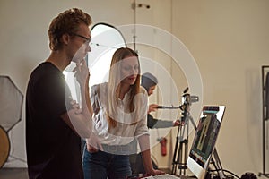 Man and woman watching photo of model on computer