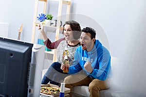 Man and woman watching tv on couch