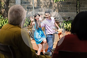 Man and woman waving goodbye to their parents after visiting them