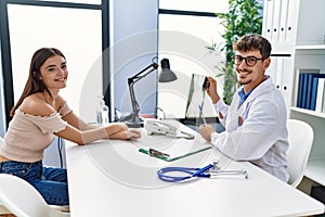 Man and woman wearing doctor uniform having medical consultation showing xray at clinic
