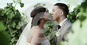 Man, woman and wedding kiss in trees for marriage event, garden celebration or romantic promise. Couple, happy and love