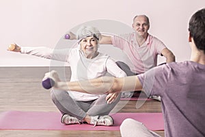 Man and woman during wellness seniors workout at gym