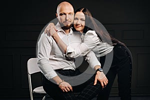 A man and a woman in white shirts on a black background.A couple in love in the studio interior