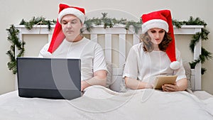 A man and a woman work overtime on a bed decorated for Christmas