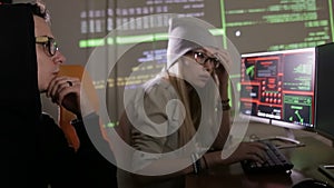 Man and woman working with computer, hacking computer system.