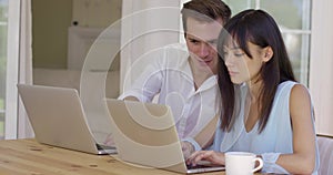 Man and woman working on laptop computers together