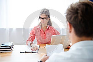 Man and woman working at office with laptop and new contract