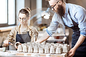 Man and woman working in the pottery shop