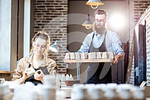 Man and woman working in the pottery shop