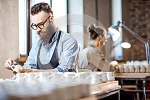 Man and woman working in the pottery shop