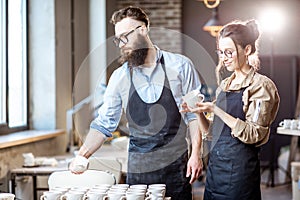 Man and woman working in the pottery shop