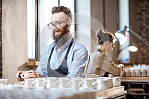 Man and woman working in the pottery shop