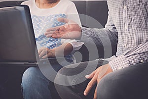 Man and woman workmate in casual dress discussing together while using laptop