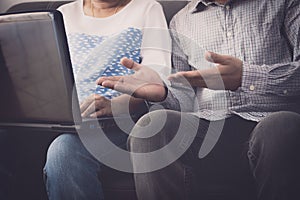 Man and woman workmate discussing together while using laptop in office