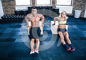 Man and woman workout with hands on fit box