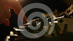 A man or woman works on a typewriter. Old typewriter on a dark background, close-up shot