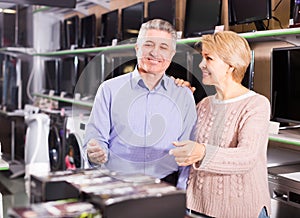 Man and woman 49-54 years old are choosing consumer electronics photo