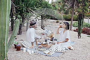 Couple on romantic date lay on picnic blanket