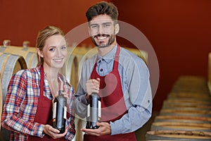 man and women coworkers showing bottles wine