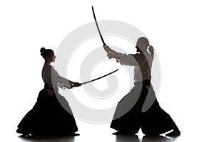 Man and woman fighting and training aikido on white studio background photo