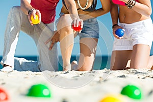 Man and women playing boule on beach photo