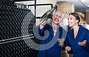 man and women winemakers with wine bottle.