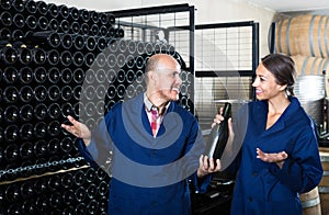 man and women winemakers with wine bottle.