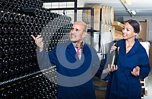 Man and women winemakers with wine bottle