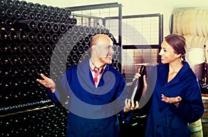 Man and women winemakers with wine bottle