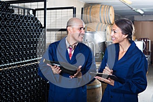 Man and women winemakers with wine bottle