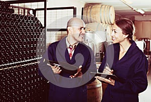 Man and women winemakers with wine bottle