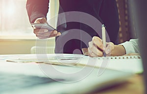 Man and women working on wooden desk in office in morning light. The concept of modern work with advanced technology. vintage effe