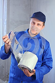 A man in work clothes holding a roll of foiled