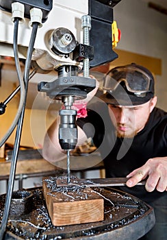 Man in work on electric drill press