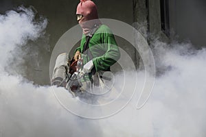 Man work fogging to eliminate mosquito for preventing spread den