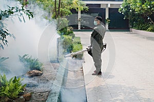 Man work fogging to eliminate mosquito for preventing spread dengue fever and zika virus photo