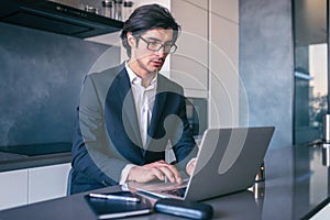 Elegant businessman works from home with a laptop. Teleworking concept photo