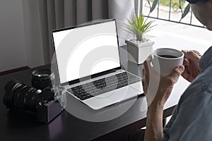 a man work at home and drinking a cup of coffee and using a laptop computer