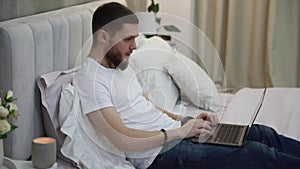 man work on laptop at home in bed