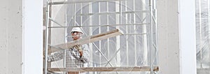 Man work, professional construction worker on scaffolding safety hard hat, gloves and protective glasses. on interior building