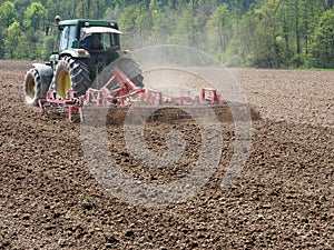 Man work with tractor and harrow