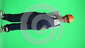A man in a work uniform on green background shows a thumbs up