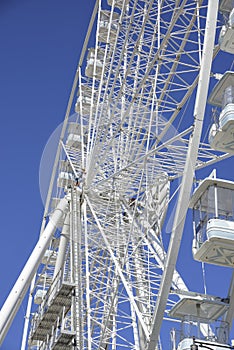Man at work on white Ferris wheel on blue sky