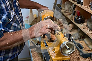 The woodturner work. Man`s arms with cutter in action.