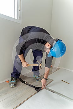 Man worker assembling laminate flooring.