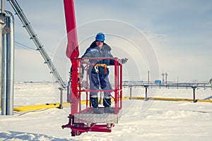 Man worker in a boom lift, machine control on the aerial platform