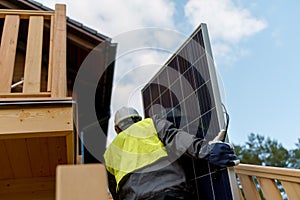 Man worker carrying solar panel for installing solar modul system on house. photo