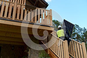 Man worker carrying solar panel for installing solar modul system on house. photo