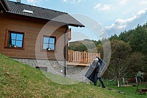 Man worker carrying solar panel for installing solar modul system on house. photo