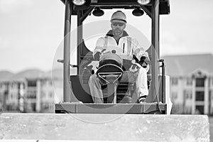 man worker at construction machinery outdoor. A construction worker used vibratory road roller. busy worker man on
